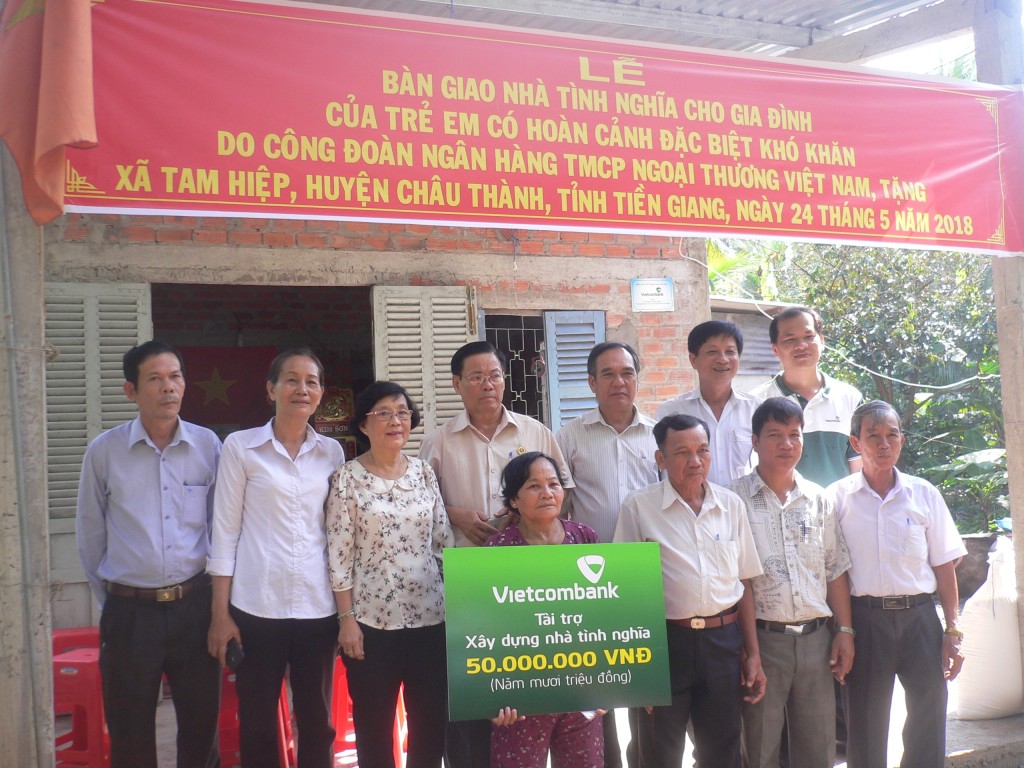 Đại diện lãnh đạo sở, ngành, đoàn thể các cấp và đại diện lãnh đạo xã Tam Hiệp cùng gia đình bà Bùi Thị Thưa chụp ảnh lưu niệm